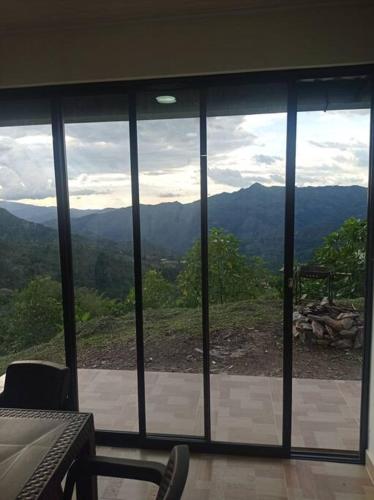 a view of the mountains through a glass window at Casa de campo en La Vega, hermosa vista, con Internet y parqueadero in La Vega