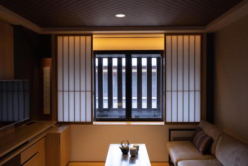 a living room with a couch and a window at Mitsui Garden Hotel Kyoto Shinmachi Bettei in Kyoto