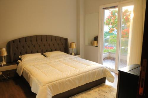 Un dormitorio con una cama grande y una ventana en كومبوند زايد ديونز en Sheikh Zayed