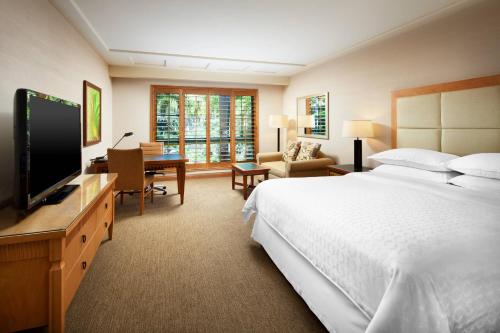 a hotel room with a large bed and a television at Sheraton La Jolla in San Diego