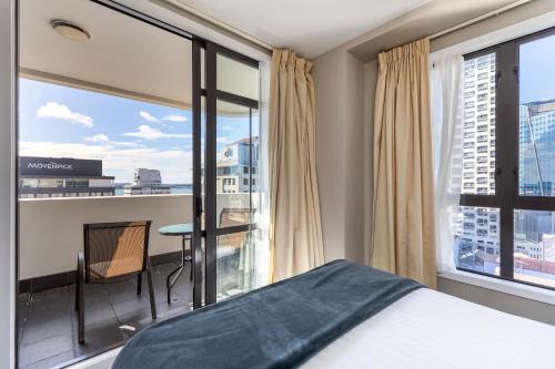 a bedroom with a bed and a large window at Quest on Queen Serviced Apartments in Auckland