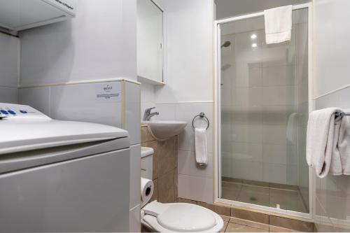 uma casa de banho com um WC, um lavatório e um chuveiro em Quest on Queen Serviced Apartments em Auckland