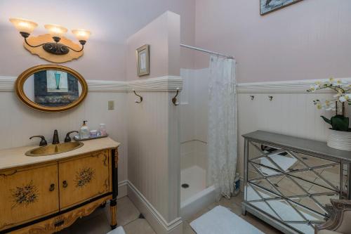 a bathroom with a sink and a shower with a mirror at Pinc Lady Mansion in Eureka