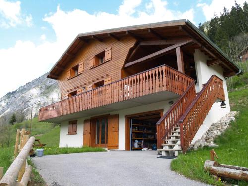 ein Holzgebäude mit einem Balkon auf einem Berg in der Unterkunft Two Bedroom Apartement Belle Vue in La Chapelle-dʼAbondance