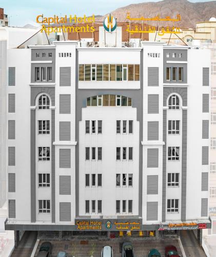 a white building with a sign on top of it at العاصمة للشقق الفندقية - Capital Hotel Apartments in Muscat