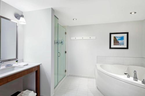 a bathroom with a tub and a sink and a shower at Four Points by Sheraton Moncton in Moncton