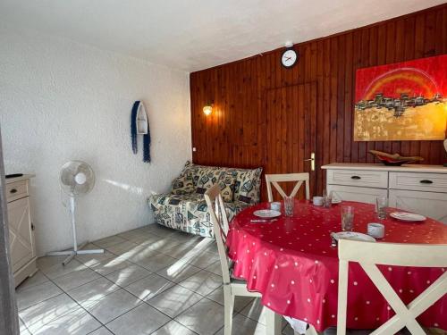 - un salon avec une table rouge et un canapé dans l'établissement Studio cabine à 200m de la plage, balcon, parking, TV, lave-linge, 4 couchages - Argelès-sur-Mer - FR-1-225-782, à Argelès-sur-Mer