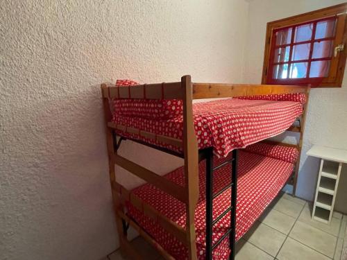Ce lit superposé se trouve dans un dortoir doté d'un lit rouge. dans l'établissement Studio cabine à 200m de la plage, balcon, parking, TV, lave-linge, 4 couchages - Argelès-sur-Mer - FR-1-225-782, à Argelès-sur-Mer