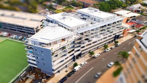 an aerial view of a large building next to a street at Ocean Lane Short Walk To Beach Accom Holidays in Terrigal