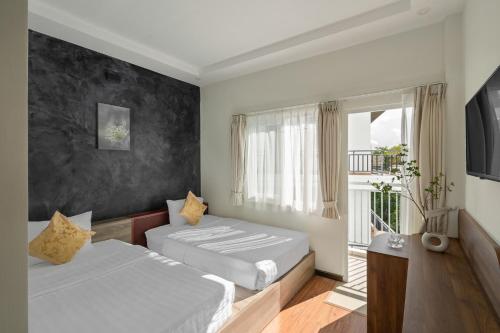a hotel room with two beds and a window at Hồng Môn Resort Đà Lạt in Da Lat
