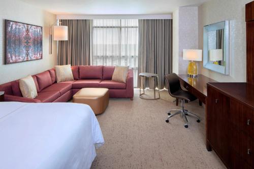 a hotel room with a bed and a couch and a desk at The Westin Mount Laurel in Mount Laurel