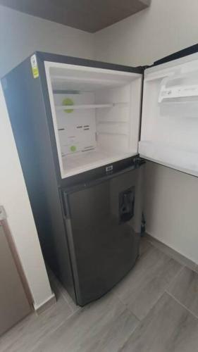 a small refrigerator with its door open in a kitchen at Apto con vista panoramica al nevado del ruiz y del tolima in Ricaurte