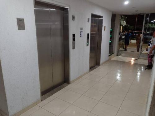 a hallway with elevators in a building with people at Apto con vista panoramica al nevado del ruiz y del tolima in Ricaurte