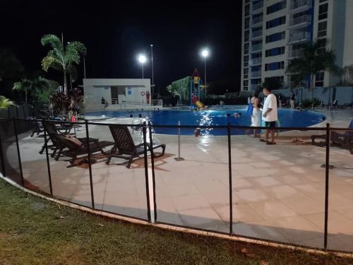 a group of people standing around a pool at night at Apto con vista panoramica al nevado del ruiz y del tolima in Ricaurte