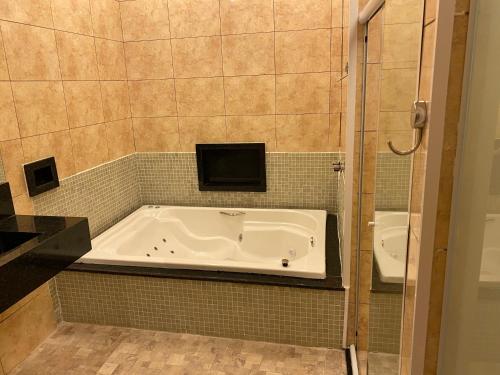 a bathroom with a bath tub and a sink at Refugius Motel in São Paulo
