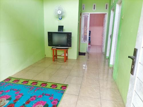 a hallway with a television and a rug in a room at SLAMET HOMESTAY TASIKMALAYA in Tasikmalaya
