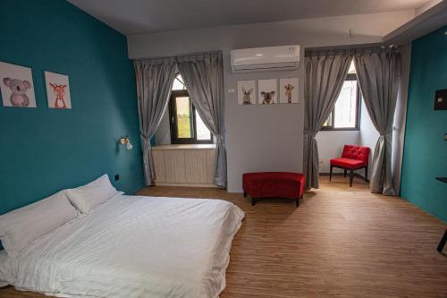 1 dormitorio con 1 cama y 2 sillas rojas en 二街館-光影民宿Light Shadow - Xinbei 2nd Street en Budai