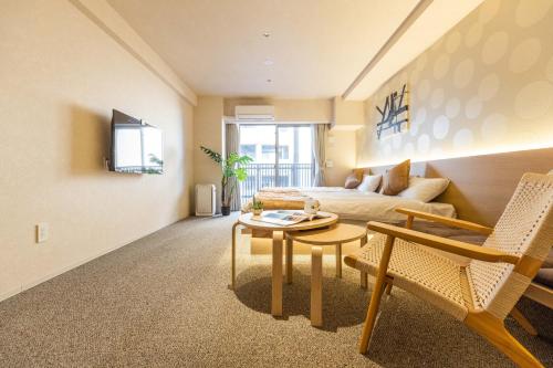 a living room with a couch and a table at Apartment Hotel 11 Namba in Osaka