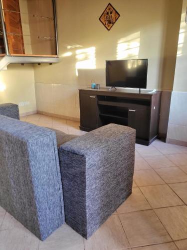 Departamento Mendoza في مايبو: غرفة معيشة مع كرسيين وتلفزيون