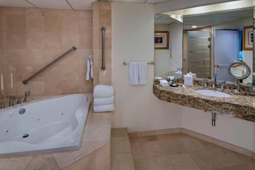 a bathroom with a tub and two sinks and a mirror at Sheraton Presidente San Salvador in San Salvador