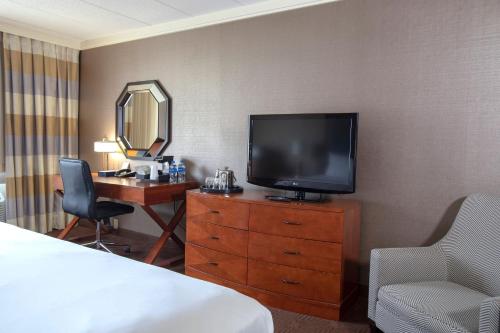 a hotel room with a television and a dresser with a mirror at Sheraton Niagara Falls in Niagara Falls