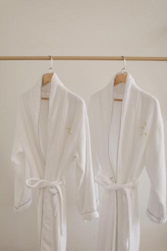 two white robes are hanging on a rack at Avatar Mountain Resort in Zhangjiajie