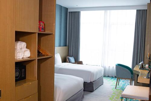 a hotel room with two beds and a window at Holiday Inn Fuyang by IHG in Fuyang