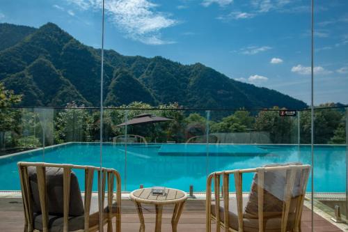 a room with a view of a pool and mountains at Avatar Mountain Resort in Zhangjiajie