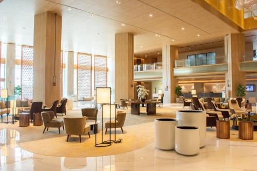 a lobby with chairs and tables in a building at Grand Richmond Stylish Convention Hotel in Nonthaburi