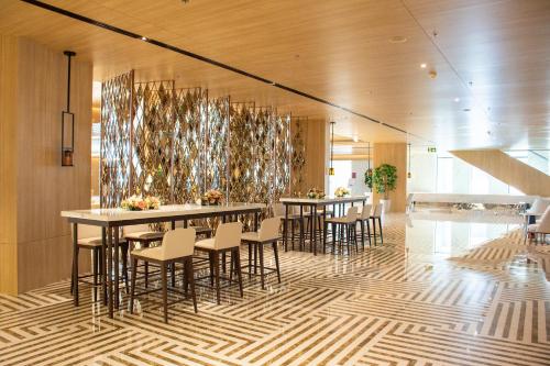 a dining room with tables and chairs in a building at Grand Richmond Stylish Convention Hotel in Nonthaburi