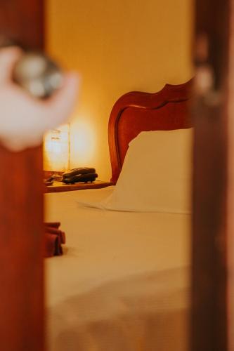 a close up of a bed with a wooden head board at Hotel Holly in Mérida
