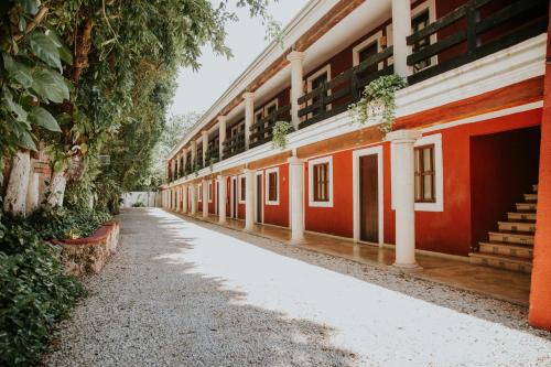 an empty corridor of an old building with trees at Hotel Holly in Mérida