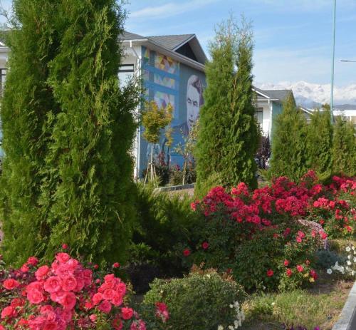 a garden of flowers in front of a house at Танхаус в Байтур резорте и Спа in Bosteri