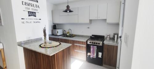 una cucina con armadietti bianchi e stufa nera di Rincon Alem a Godoy Cruz