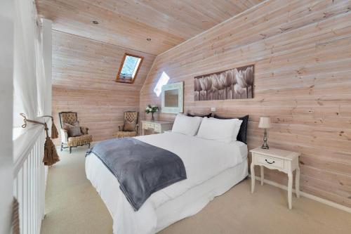 a bedroom with a bed and a wooden wall at The Barn Burradoo in Burradoo