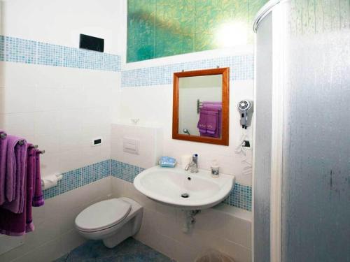y baño con lavabo, aseo y espejo. en La Brezza B&B Ischia, en Isquia