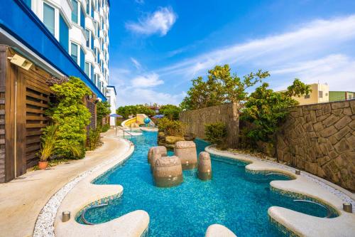 una piscina en un patio trasero con un tobogán de agua en Kenting Long Beach Hotel en Checheng