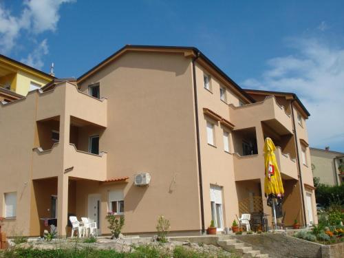 a building with a yellow umbrella in front of it at Apartments Crikvenica in Crikvenica