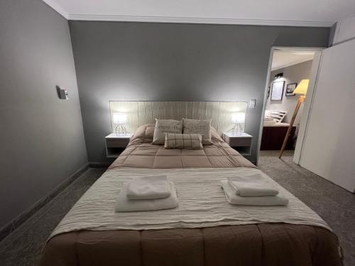 a bedroom with a large bed with two towels on it at Departamento frente a plaza libertad 1hab in Santiago del Estero