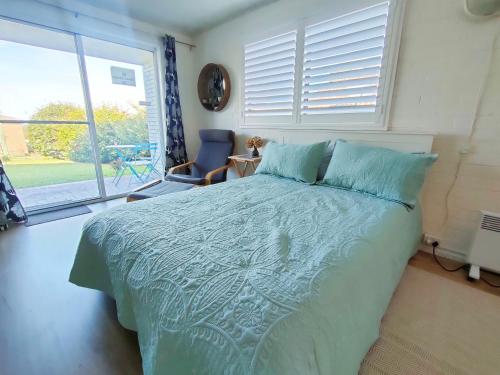 a bedroom with a bed and a large window at Swan Place In The Heart of Kiama in Kiama