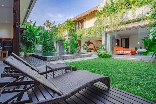 水明漾‎的住宿－Villa Elyse Seminyak，一个带椅子的户外庭院和一个草坪