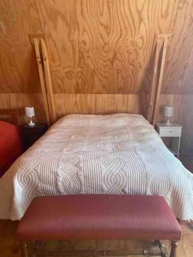 a bed with a red bench in a bedroom at Depto. interior 1 ambiente acceso independiente in San Pedro de la Paz