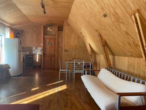 een woonkamer met een tafel en een koelkast bij Depto. interior 1 ambiente acceso independiente in San Pedro de la Paz