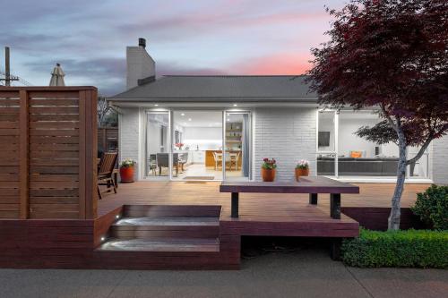 a wooden deck with a bench and a house at Family-Friendly, Home & Garden, 4BR, by Airport, Free Parking in Christchurch