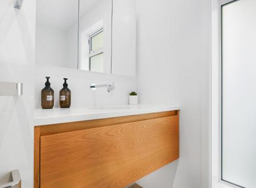 a bathroom with a sink and a mirror at Family-Friendly, Home & Garden, 4BR, by Airport, Free Parking in Christchurch