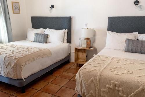 1 dormitorio con 2 camas y una lámpara en el suelo de baldosa en Mestizo Antigua, en Antigua Guatemala