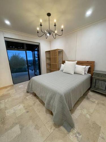 a bedroom with a bed and a chandelier at Adelaide and Adelaide Hills self contained private guest suite in Montacute