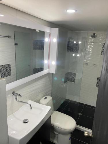 y baño con aseo, lavabo y ducha. en apartamento en Medellin, Santa Monica en Medellín