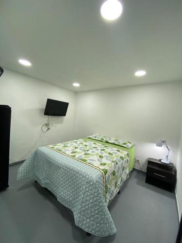 um quarto com uma cama e uma televisão em apartamento en Medellin, Santa Monica em Medellín