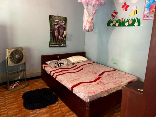 1 dormitorio con 1 cama y ventilador en OM Homestay, en Bentota